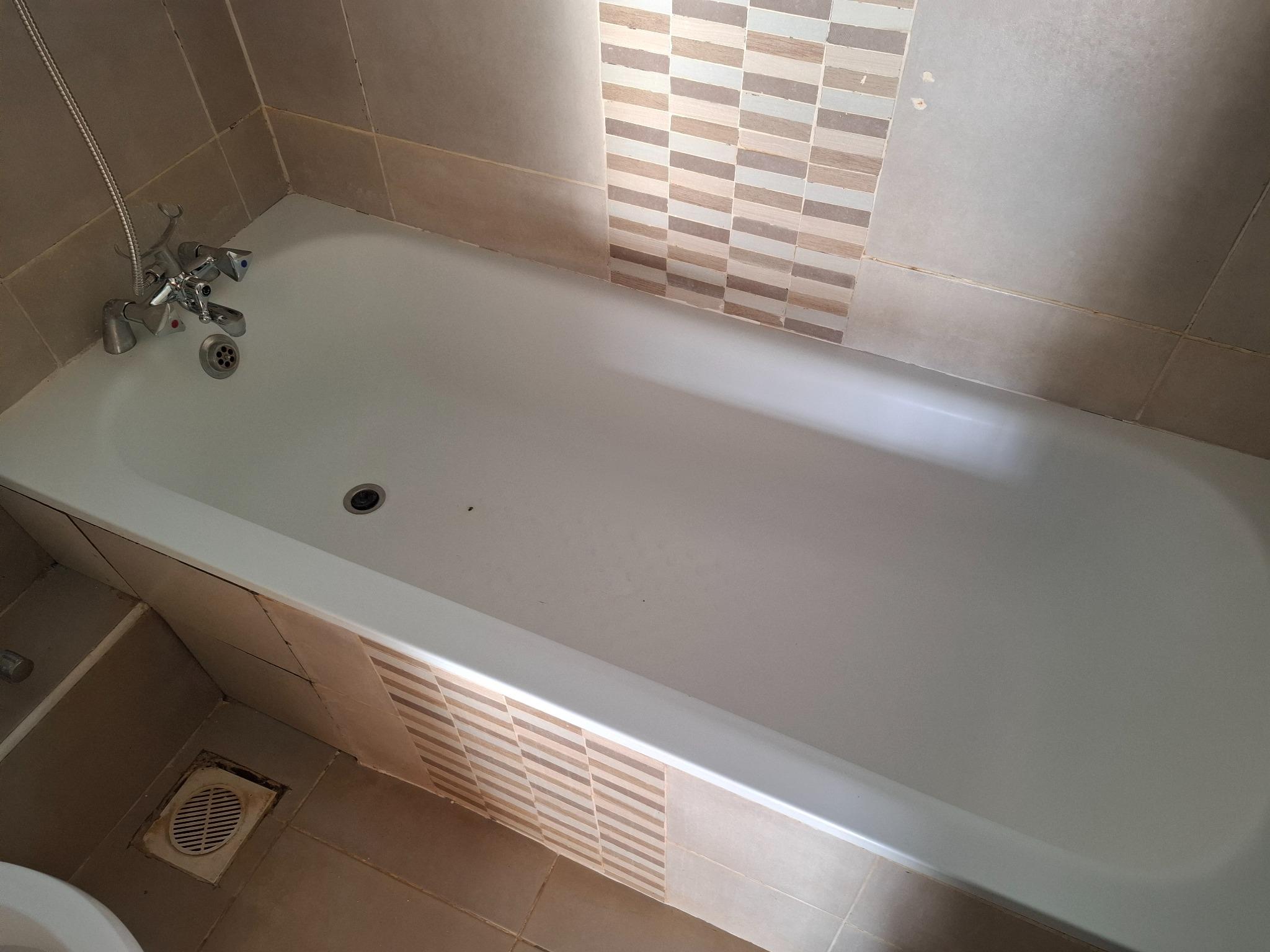 Finishing details: the bathtub and surrounding tiled surfaces after cleaning.