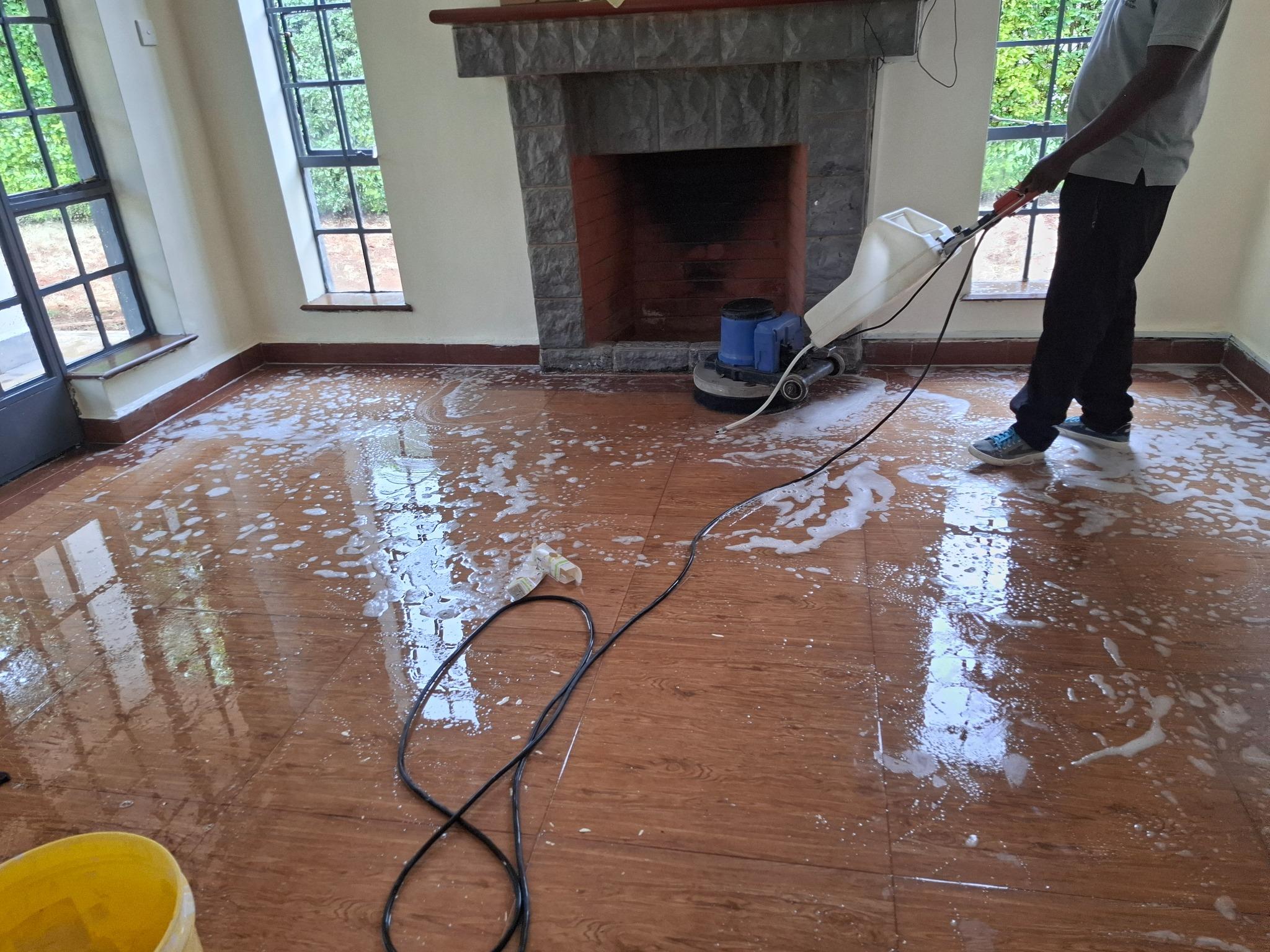 Machine scrubbing a tiled living-room floor during post-construction cleaning