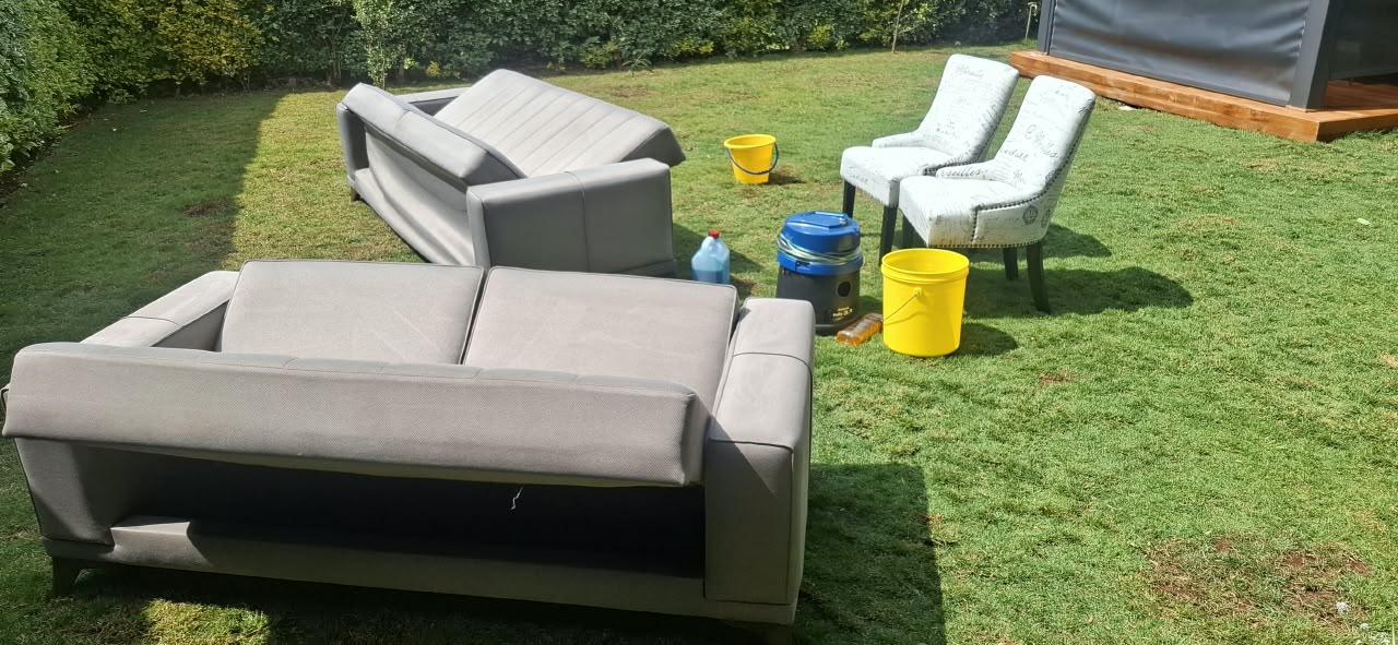 Sofas, upholstered chairs and cleaning equipment arranged for an on-site visit.